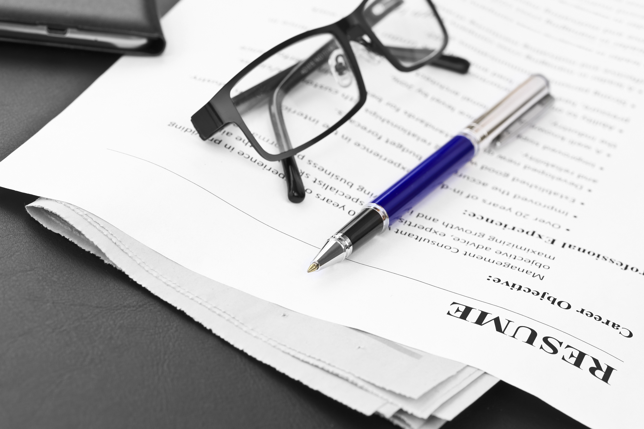 Closeup of resume with pen and glasses on the table
