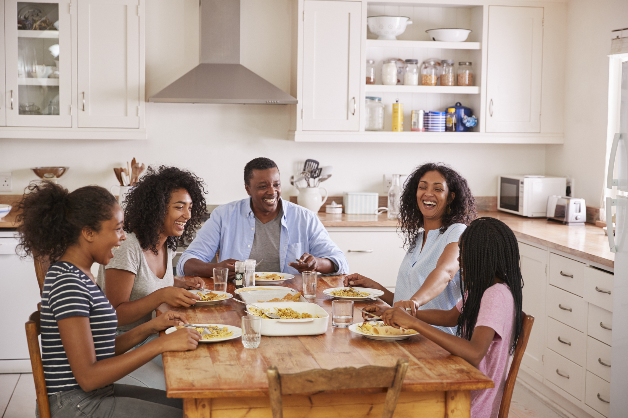Family With Teenage Children Eating Meal In Kitchen