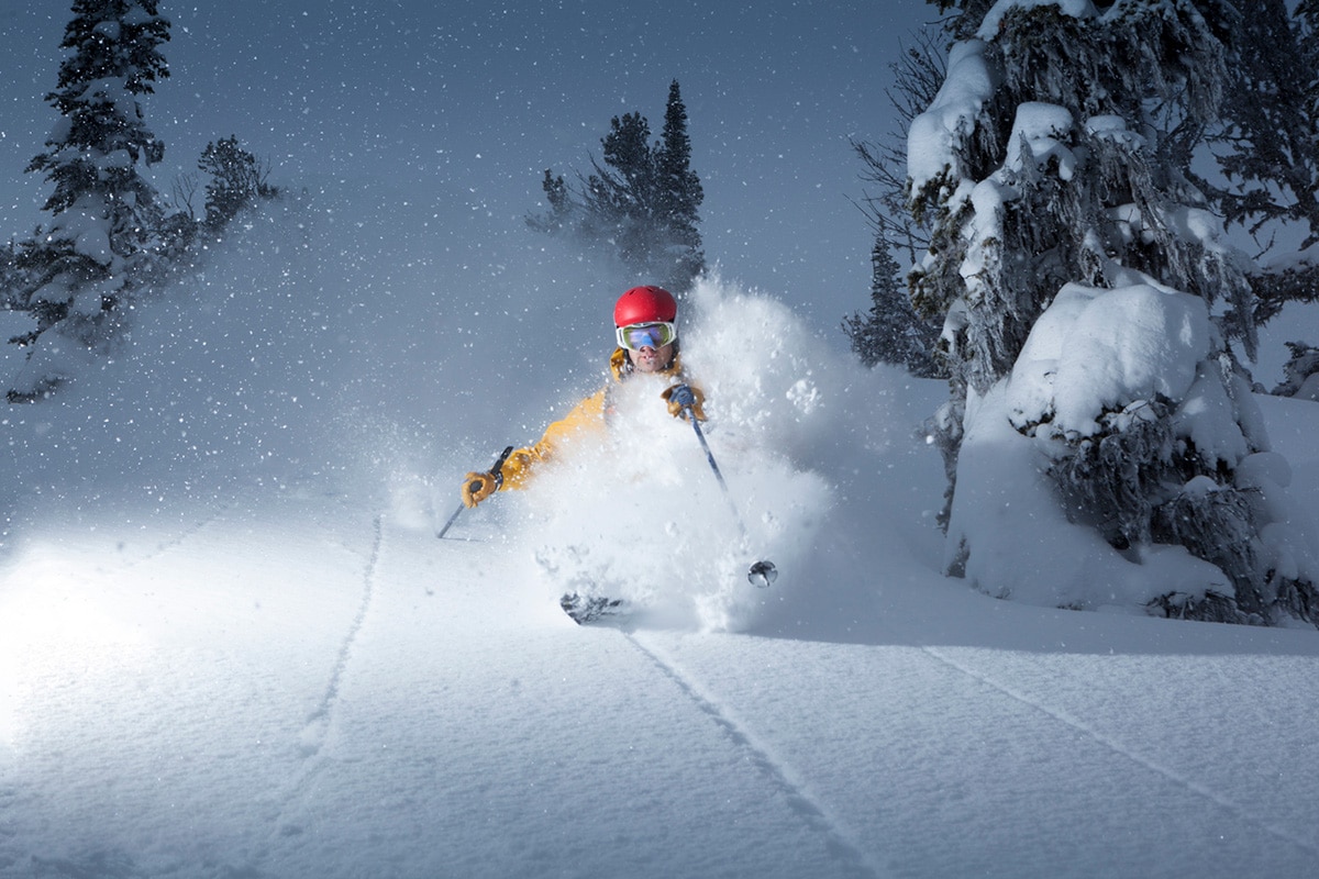 Skier kicking up powdery now descending a B.C. mountain