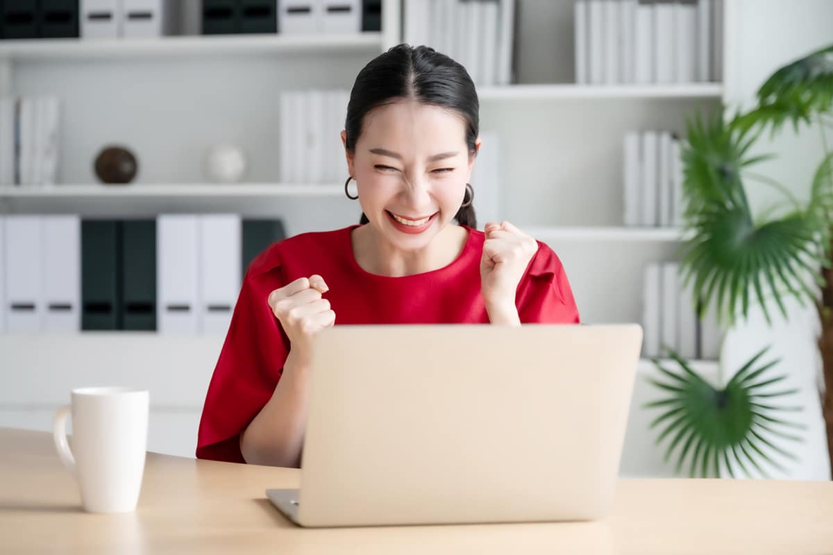 Woman celebrating at computer