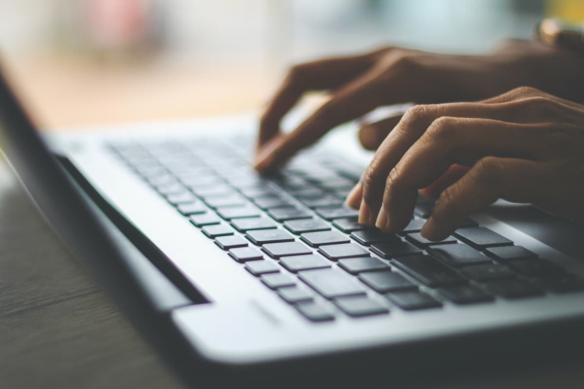 Fingers typing on a laptop.