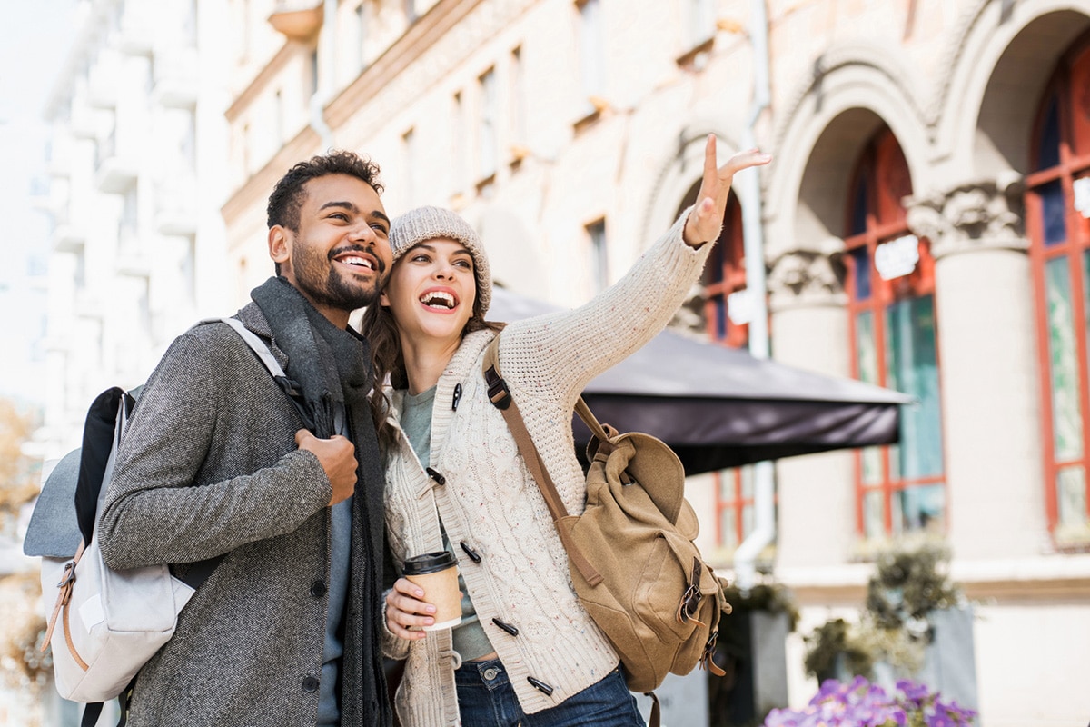 Couple smiling, pointing at colonial architecture
