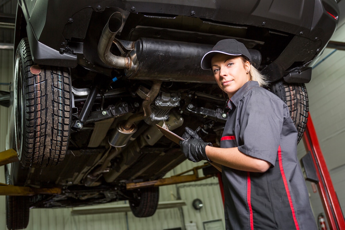 Mechanic examining vehicle underbelly