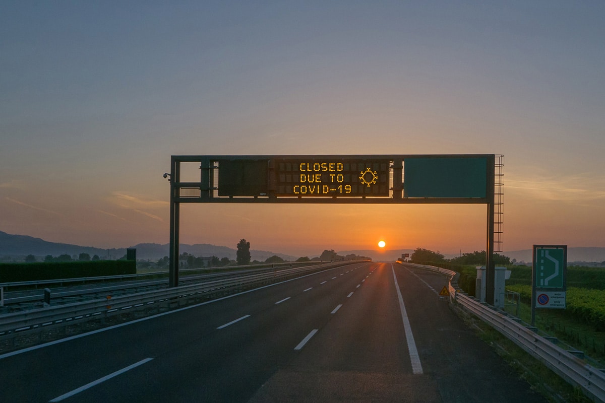 Sign over a highway that says "Closed due to COVID-19."