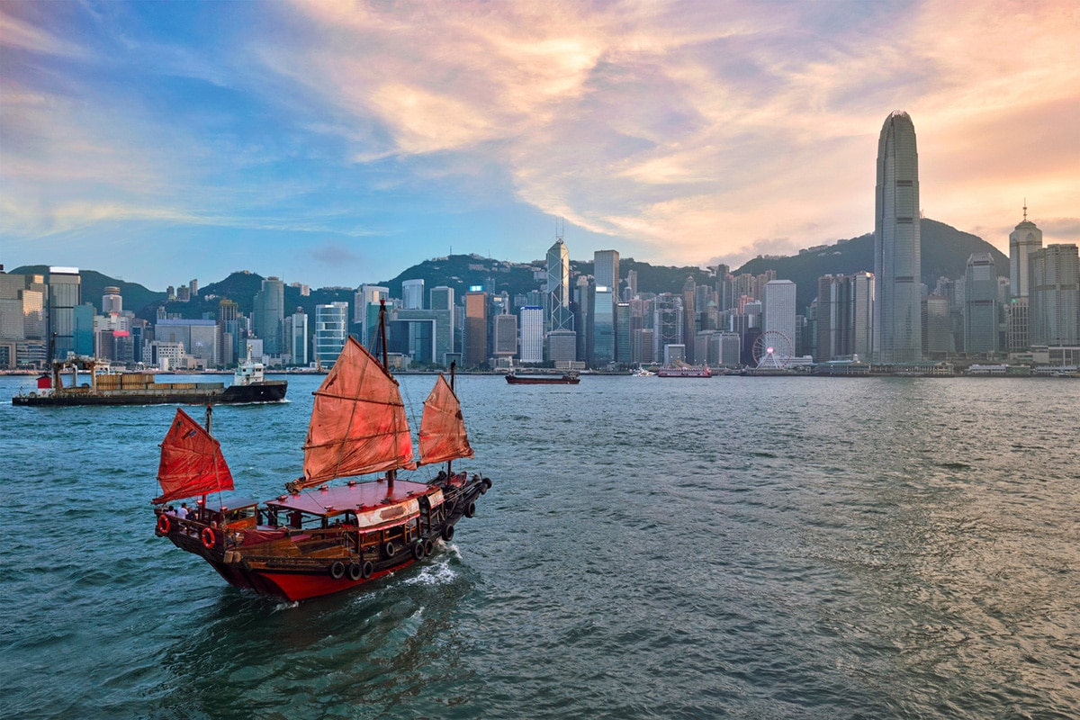 Hong Kong skyline with junk tourist ferry boat on Victoria Harbour
