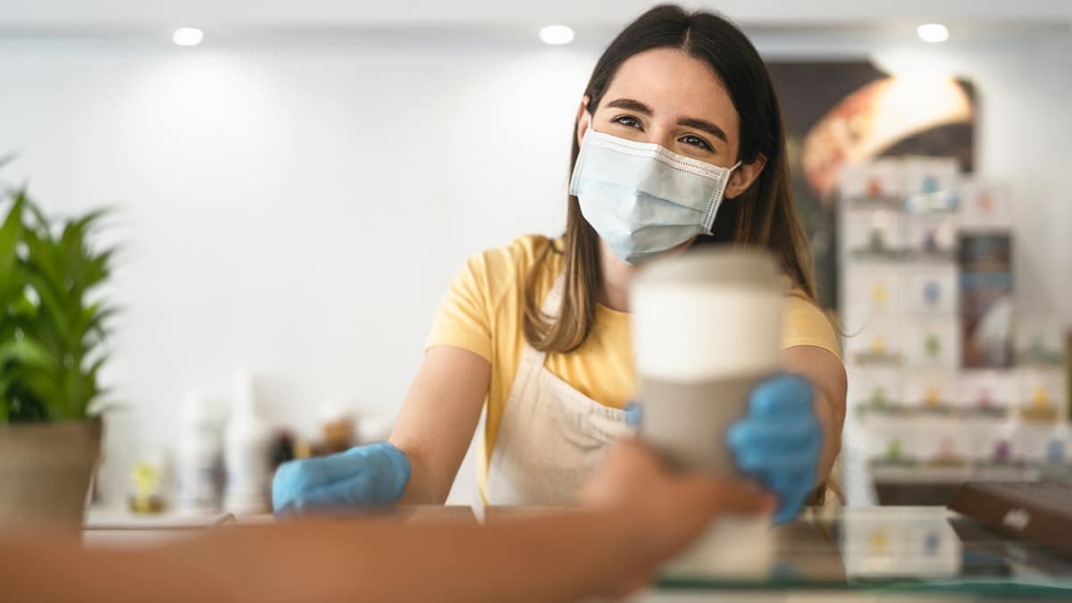 Cafe worker handing coffee to customer