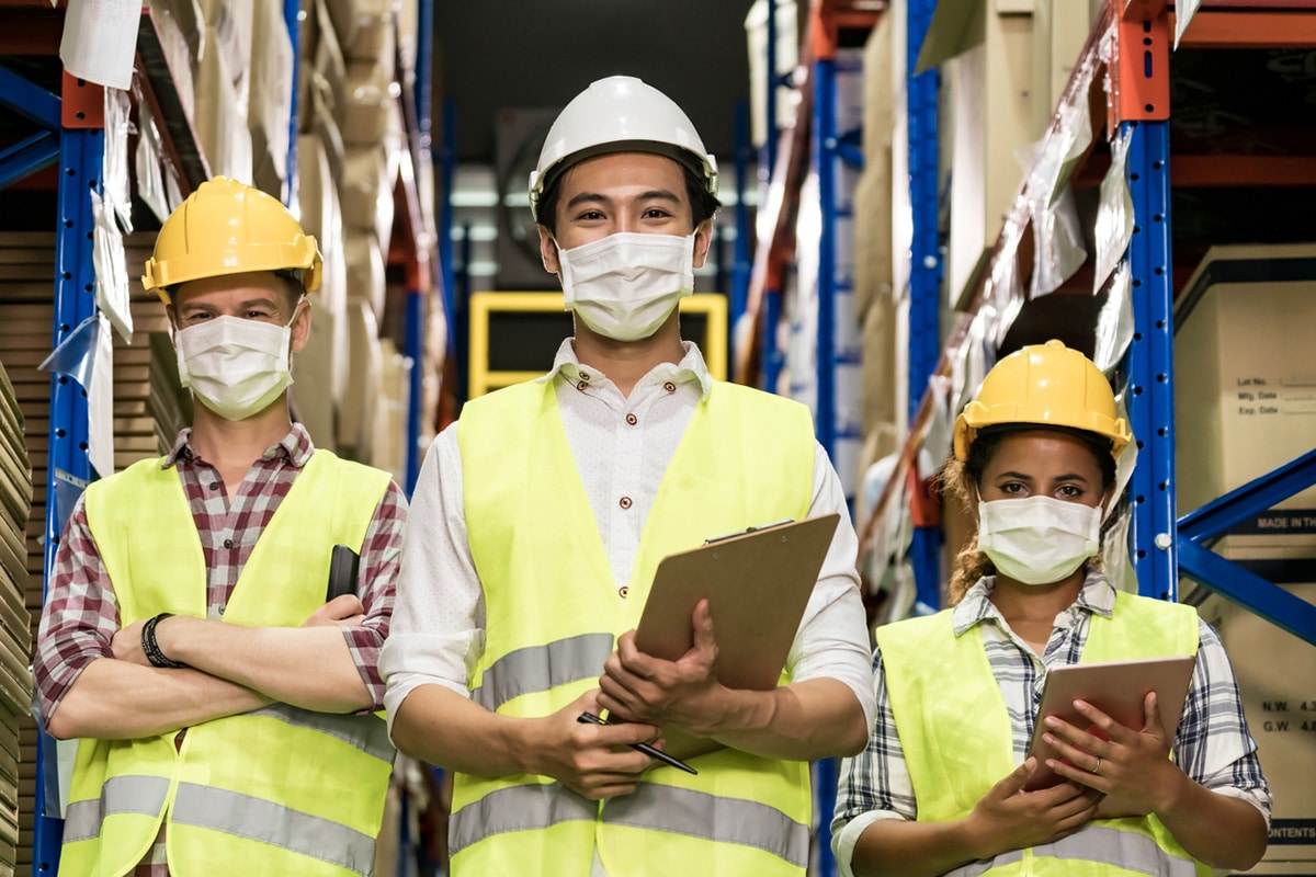 Three workers wearing COVID masks, facing the camera.