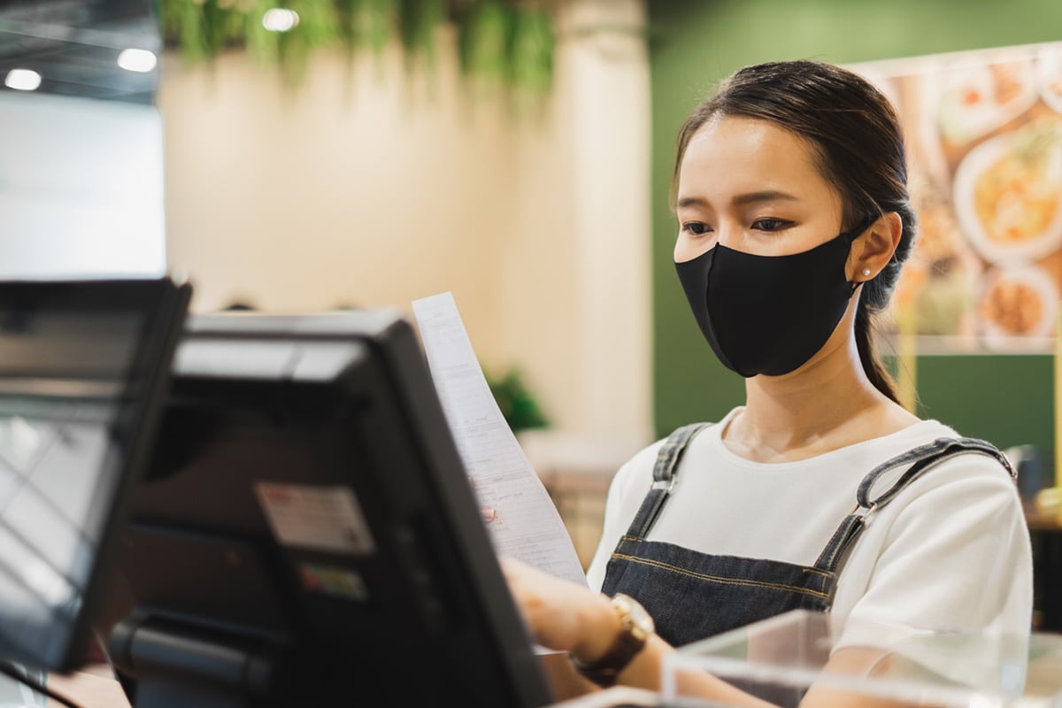 Woman working at a restaurant wearing COVID mask