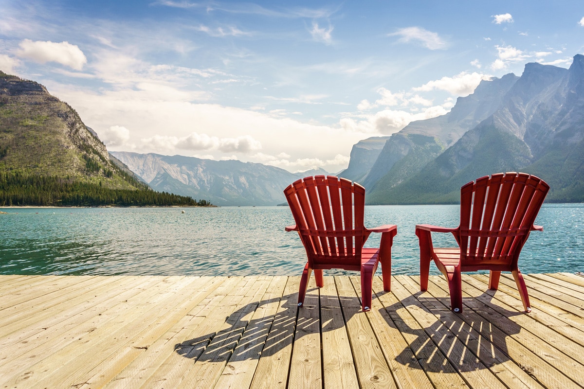 Two empty chairs facing lake and mountains in Banff, Canada