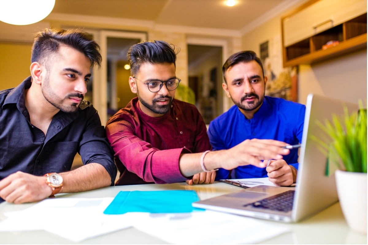 Tech workers looking at a computer.
