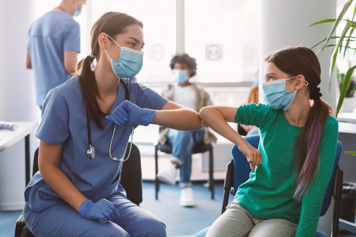 Nurse and patient giving each other the COVID high five with their elbows