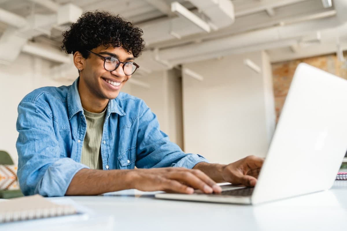 International student graduate on laptop.