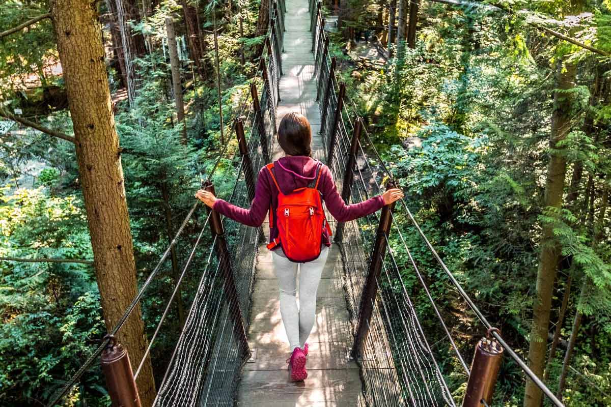 Woman walking across Capilano Bridge in Vancouver, Canada.