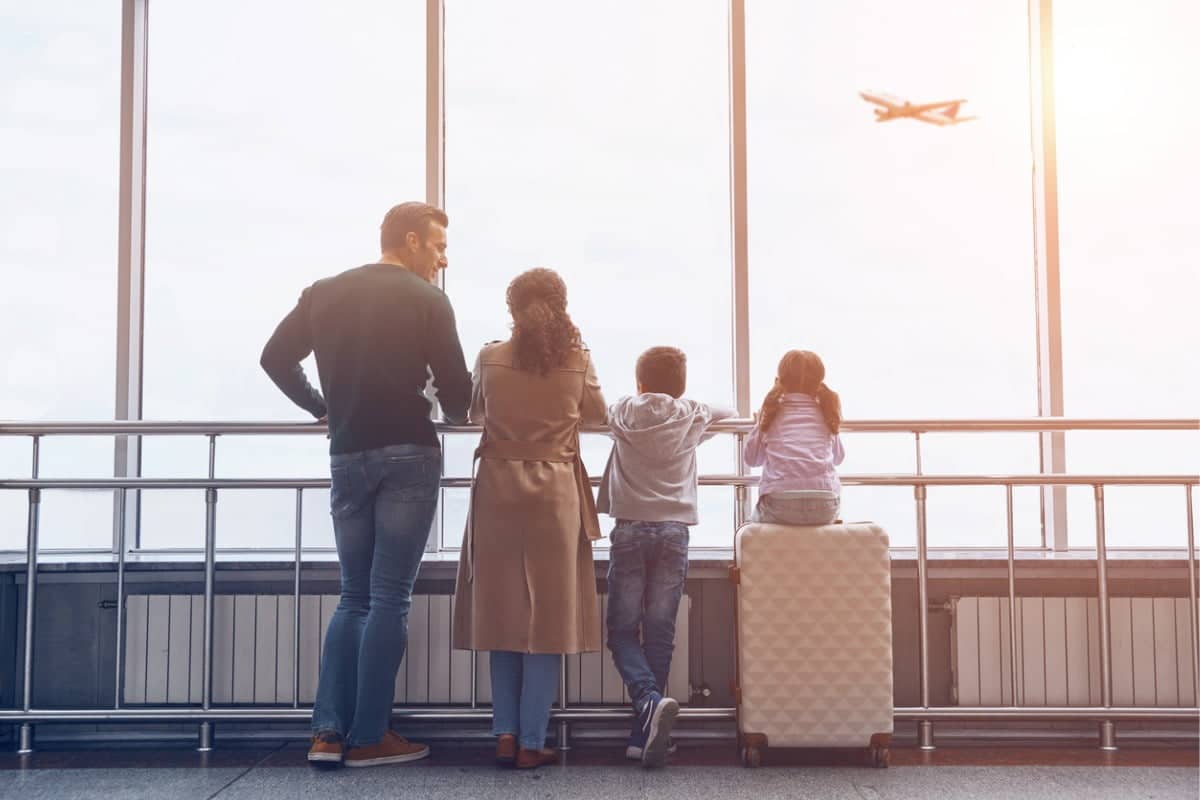 Family of four looking out of an airport window