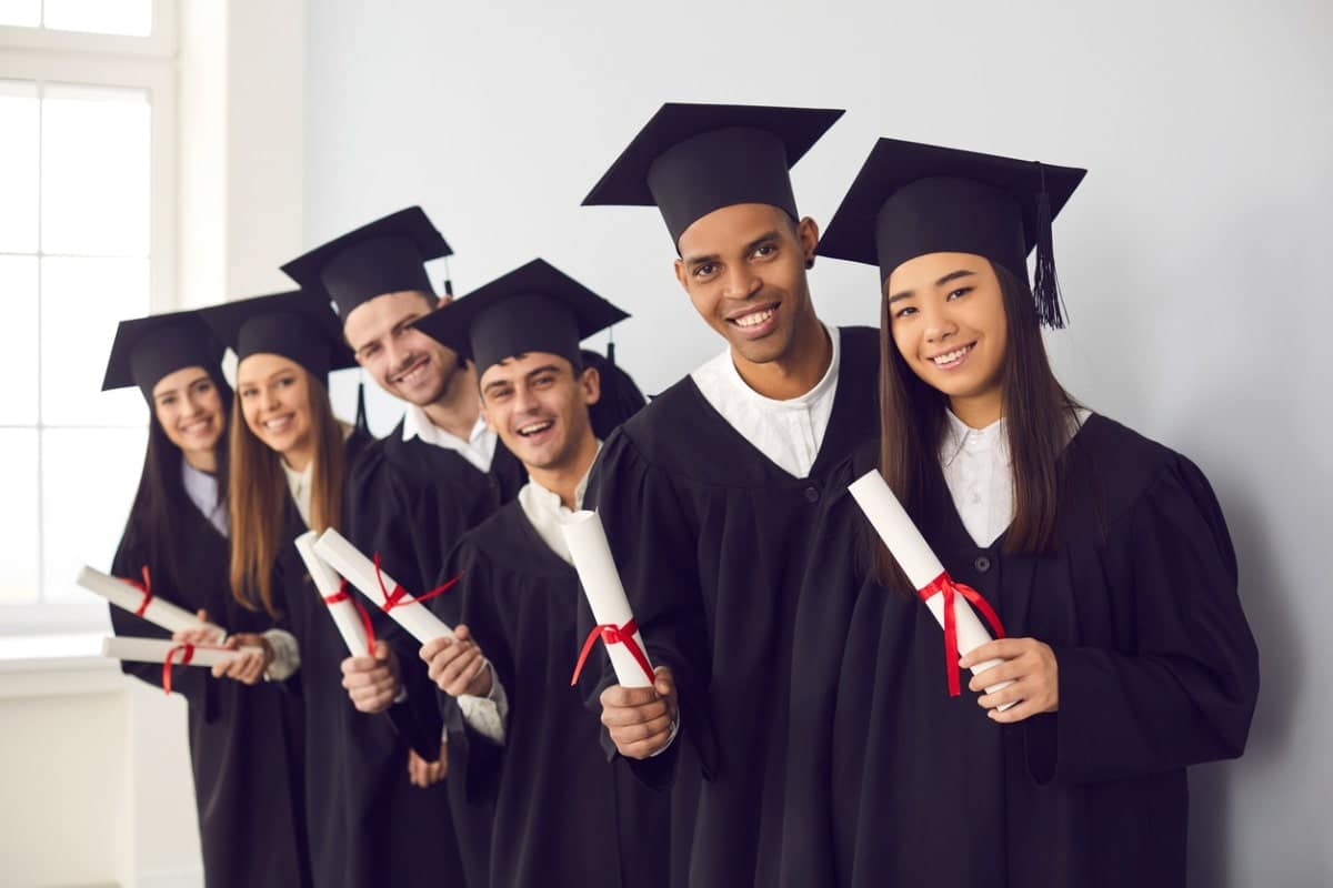a group of international students holding diplomas and smiling together