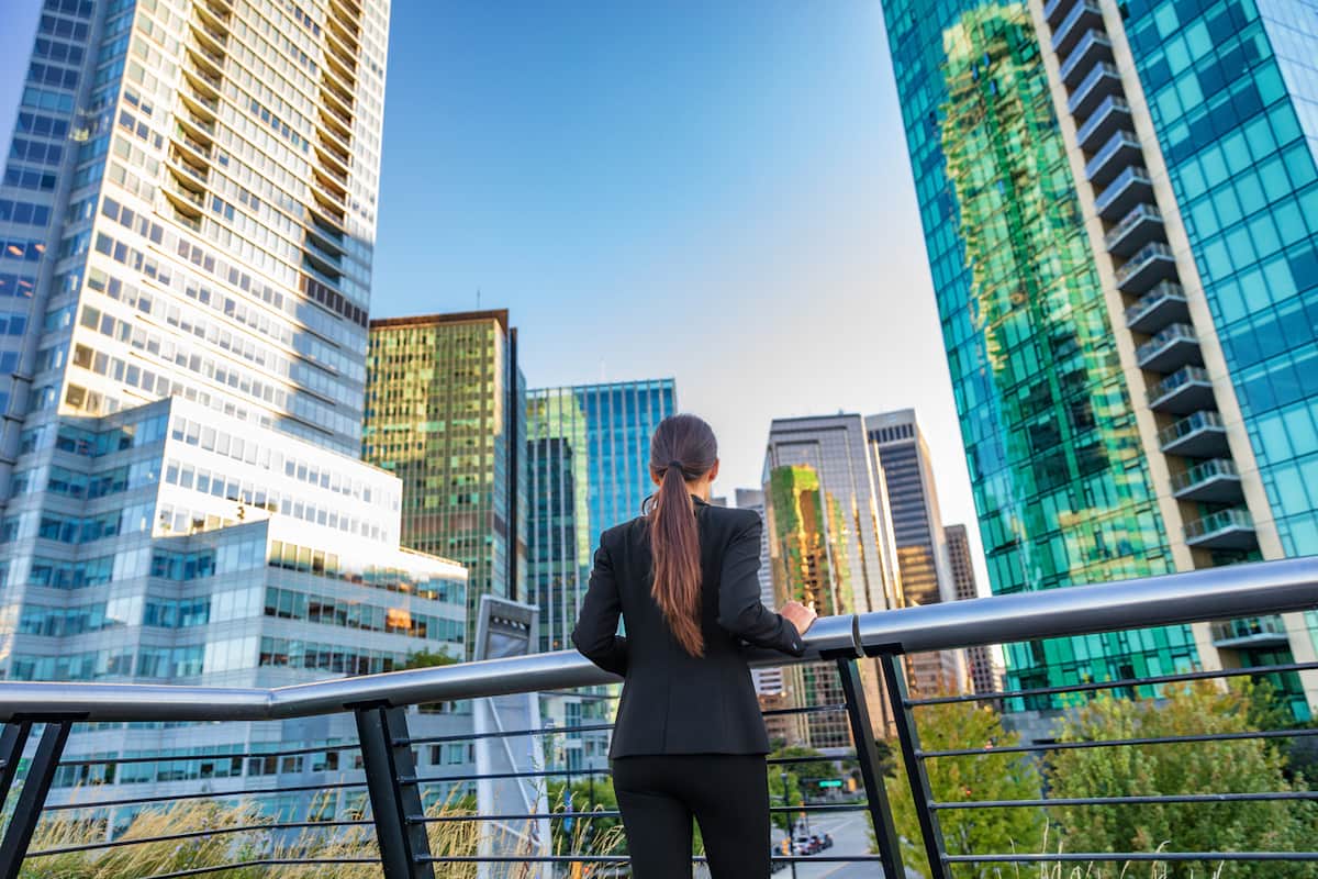 Woman standing in front of high-rise buildings in Vancouver. This year Canada will welcome over 400,000 immigrants.
