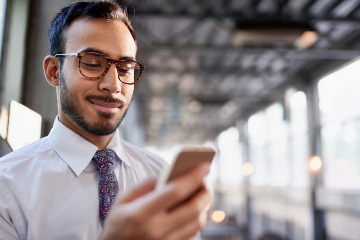 man standing and smiling at cellphone