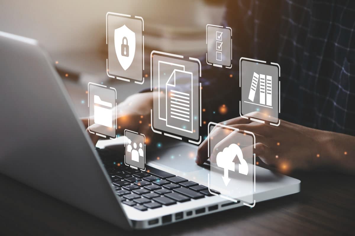 business person using computer with graphics coming out of it