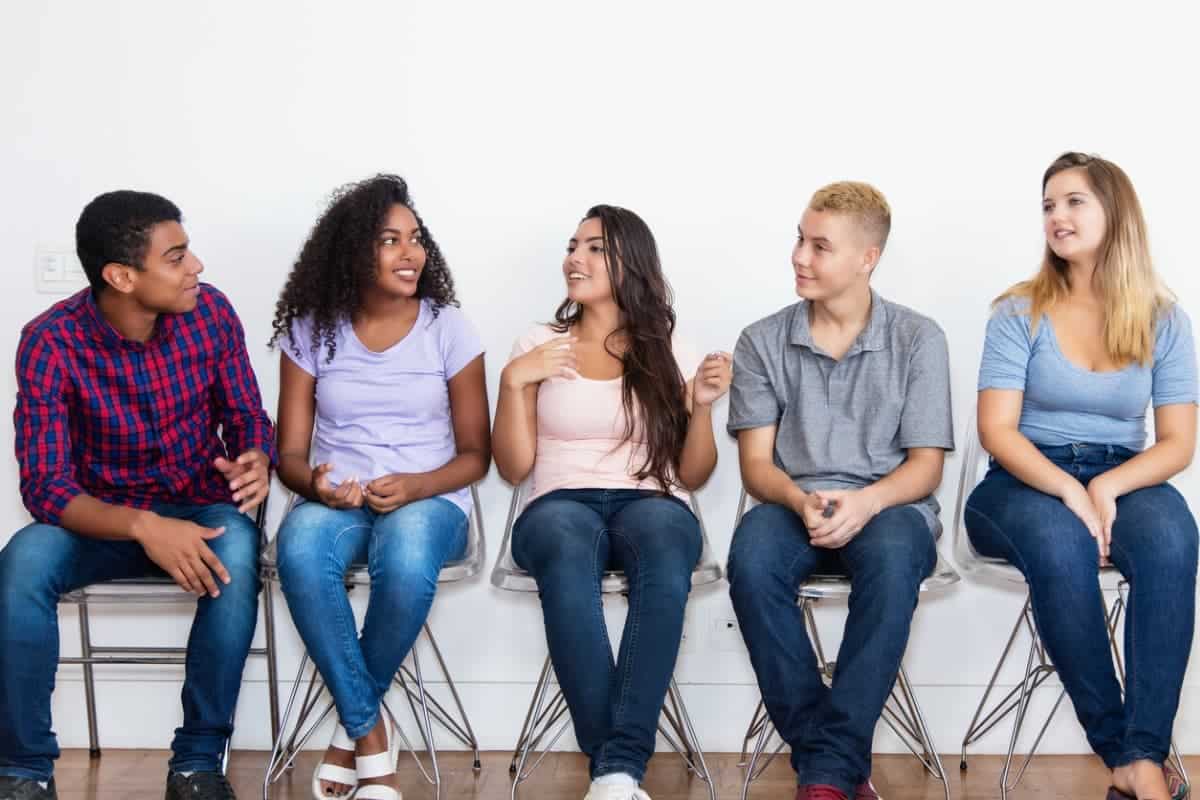 group of young people sitting together talking