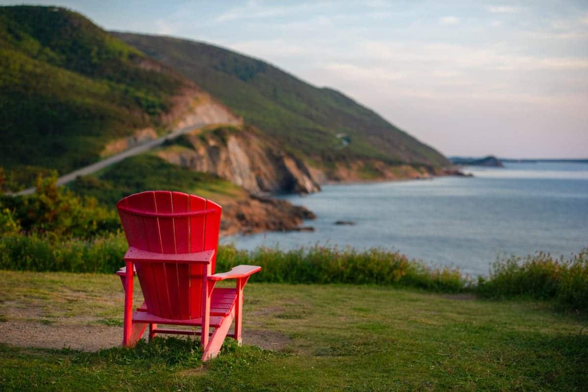 red chair on hill outlooking a body of water
