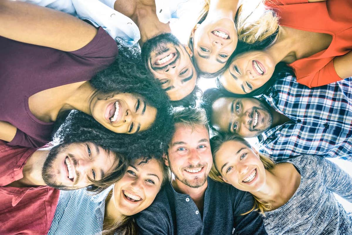 A group of people looking down at a camera smiling. EE draws resumed in 2022 bringing CRS cut-offs to the forefront of EE immigration.