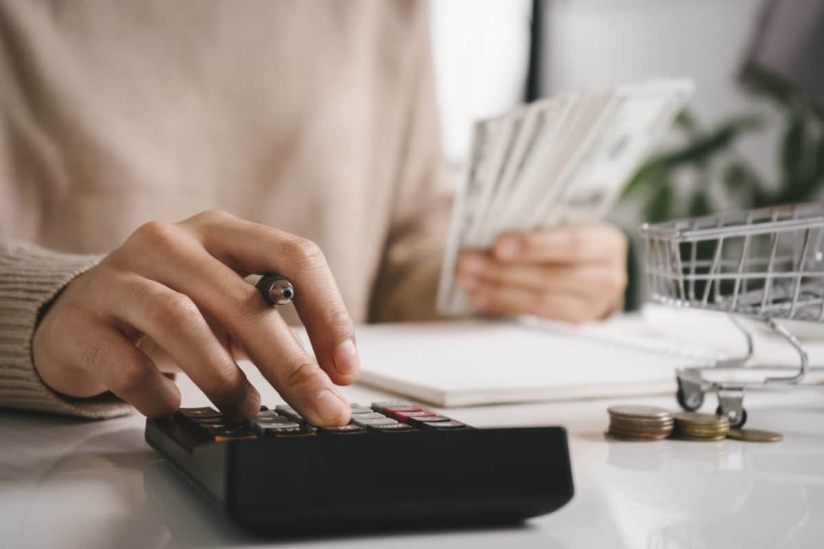 woman counting money and calculating costs on a calculator