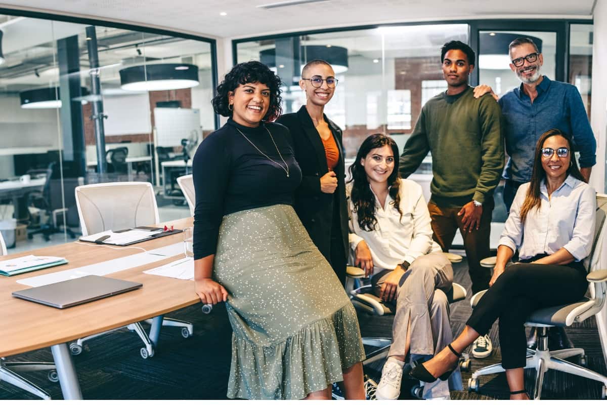 Team of businesspeople smiling at the camera in a boardroom