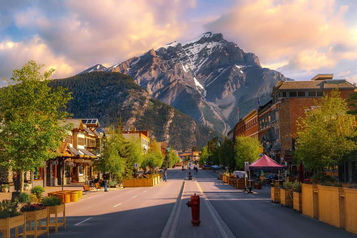 Sunrise Clouds Over A Mountain Road Through The Town Of Banff.
