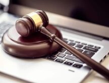 A hammer and gavel placed above a laptop.