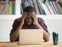 A man looking dejected in front of a laptop. Misrepresentation can be a serious offence and leave people inadmissible for immigration to Canada.