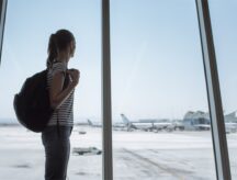 Happy female traveler waiting for the flight in the airport