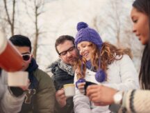 Group of millenial young adult friends enjoying wintertime and in a snow-filled park