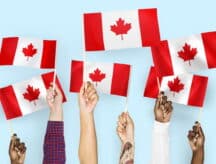 Diverse hands holding up Canadian flags