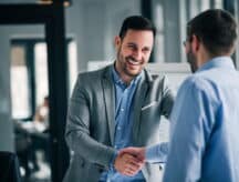 Portrait of cheerful young manager handshake with new employee.