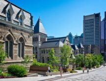 Students walk on a pathway outside a historic university building