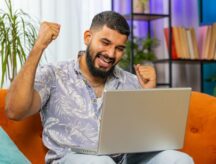 Young man looks happy while staring at laptop