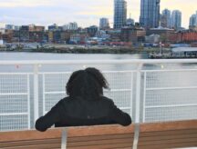 a woman looking at Vancouver, BC Canada harbor.