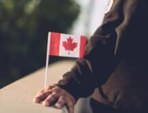 Hand holding Canadian flag
