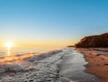 Waves splashing against the shore at Thunder Cove Beach in PEI at sunrise.