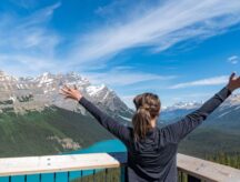 A woman stands facing Banff scenery