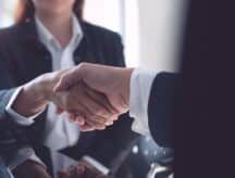 People in corporate setting shake hands