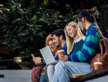 A group of students happily discussing the possibility of immigrating on campus.